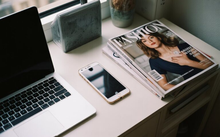 Bureau appartement, ordinateur fermé, téléphone, magazine.
