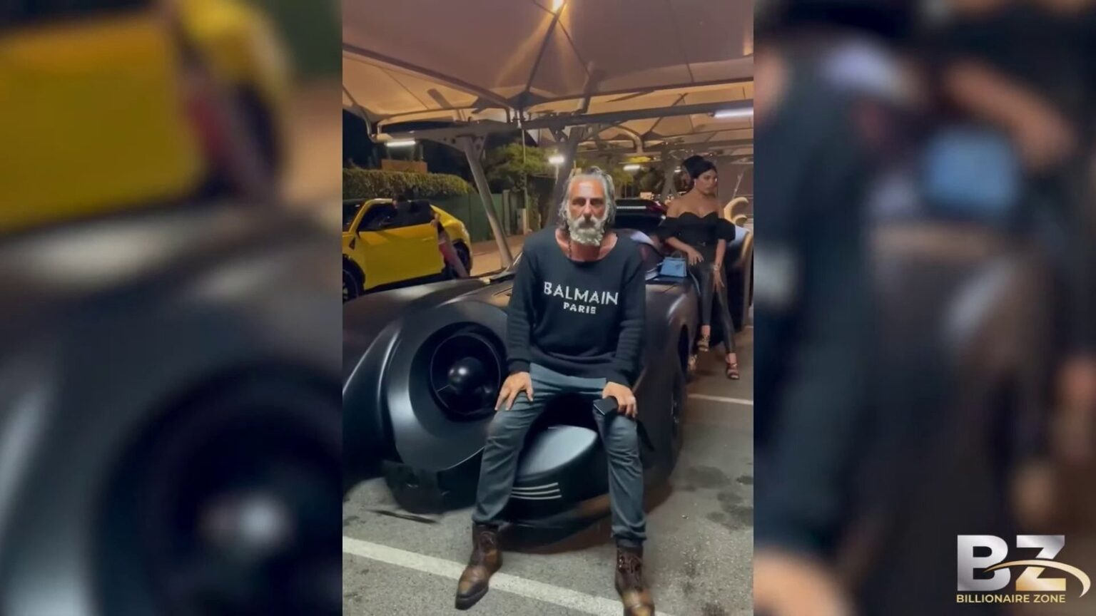 Ilan Tobianah, surnommé Zeus, posant devant des voitures de luxe illustrant sa fortune en 2024