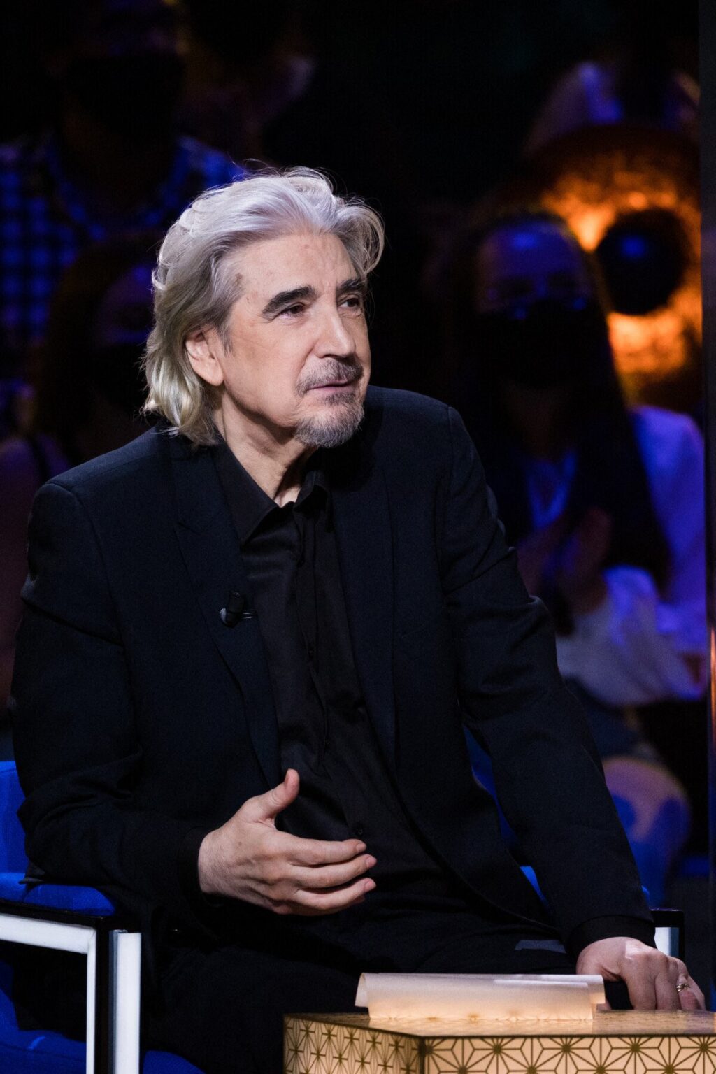 Serge Lama lors d'un enregistrement télévisé, symbole de sa longue carrière et de sa notoriété