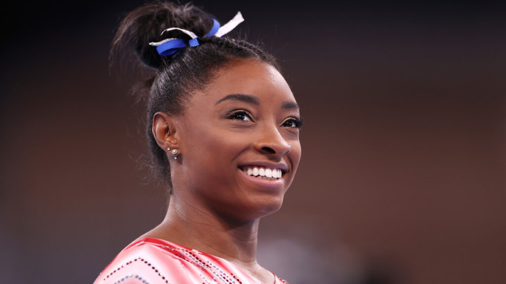 Simone Biles souriante illustrant sa réussite financière en 2025