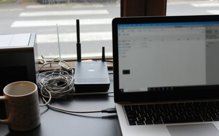 Bureau français, routeur Wi-Fi, câbles, écran flou
