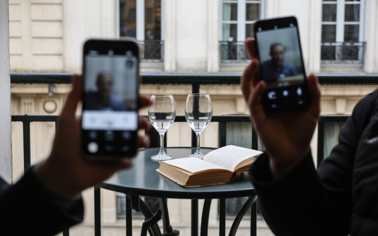 Deux verres et livre sur balcon français.