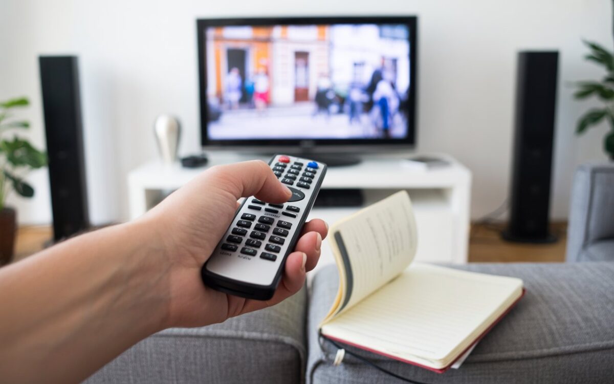 Main, télécommande universelle et télé floue