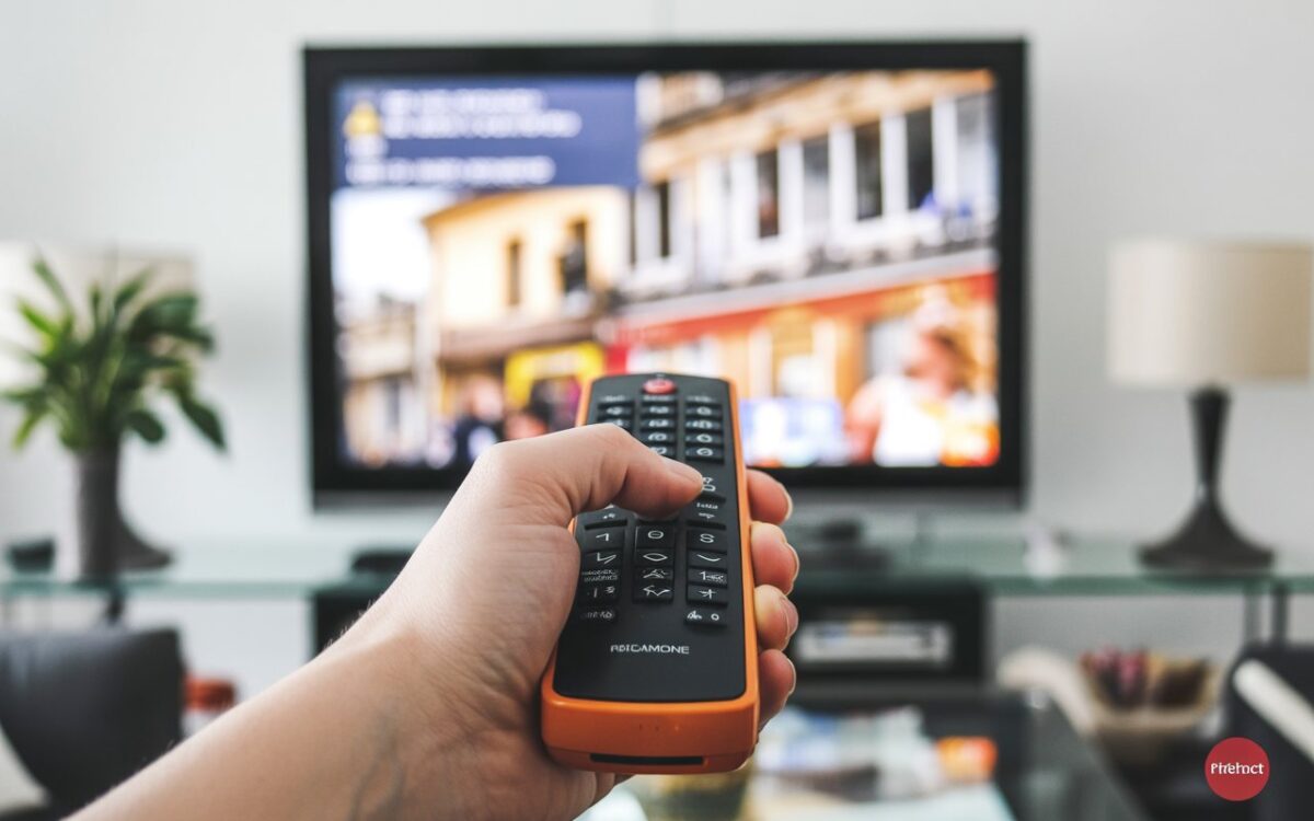Main, télécommande orange et décodeur
